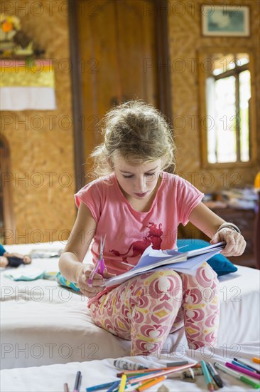 Caucasian girl coloring in bedroom