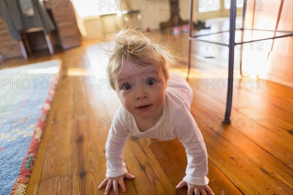 Caucasian baby crawling on floor