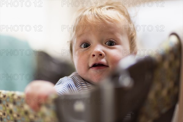 Caucasian baby standing in laundry basket