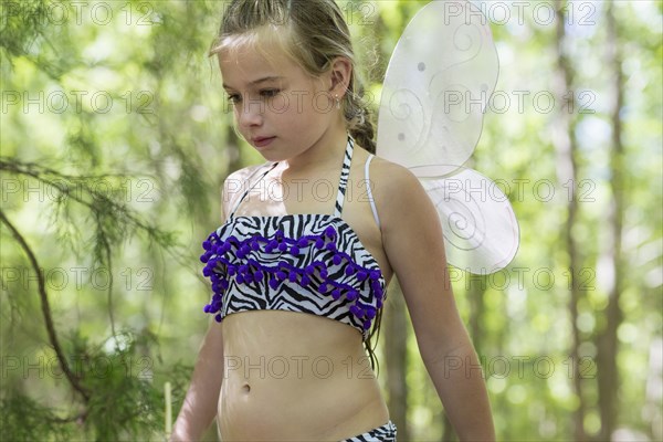 Caucasian girl playing dress up in forest