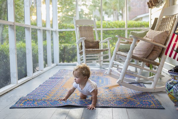 Caucasian baby crawling on porch