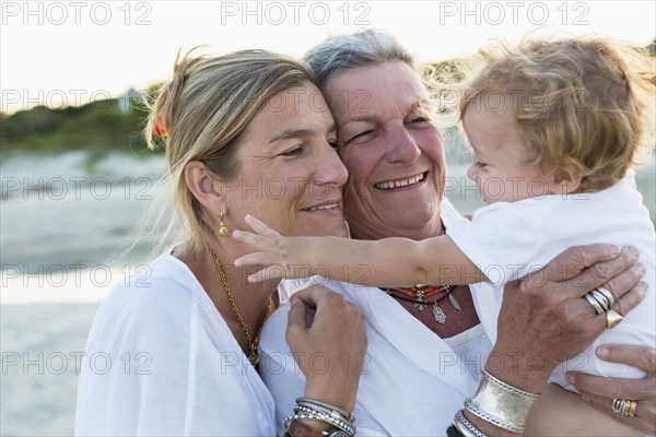 Three generations of Caucasian family on beach