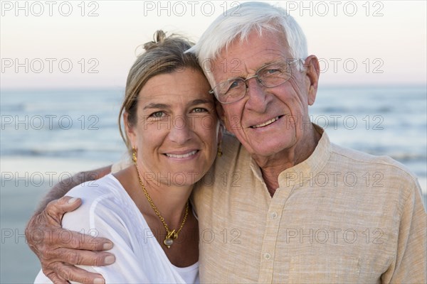 Caucasian father and daughter smiling on beach