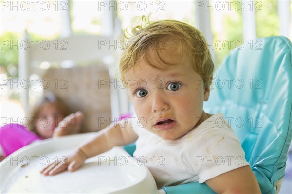 Caucasian boy sitting in high chair