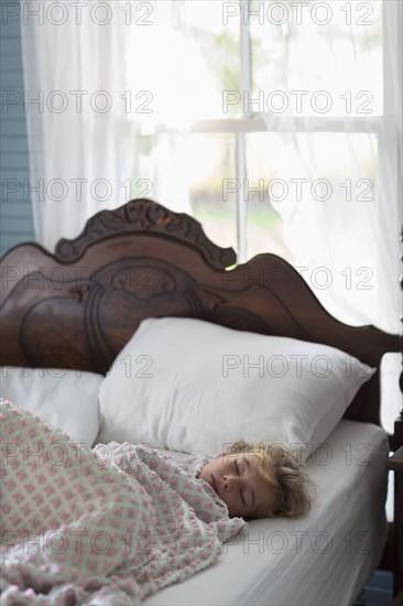 Caucasian girl asleep in bed