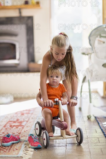 Caucasian girl and toddler brother playing in living room