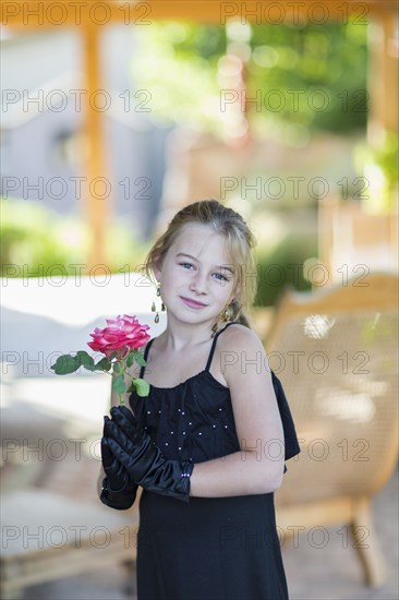 Caucasian girl playing dress-up on porch