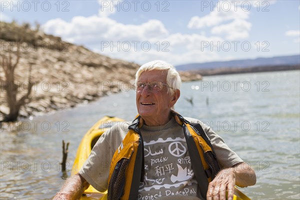 Older Caucasian man rowing on lake