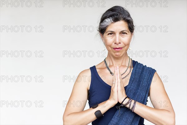 Older Hispanic woman with hands clasped