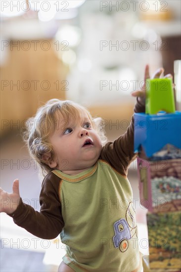 Caucasian baby boy reaching for blocks