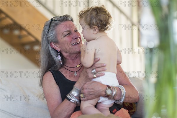 Caucasian grandmother holding grandson outdoors