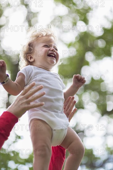 Caucasian mother playing with baby boy outdoors