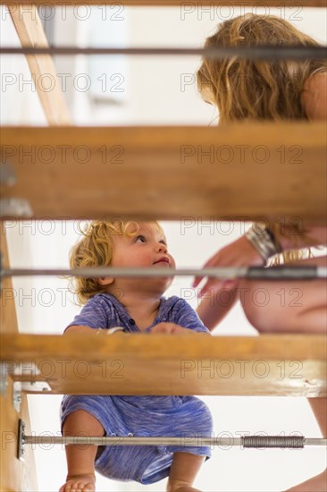 Caucasian girl helping baby brother on staircase