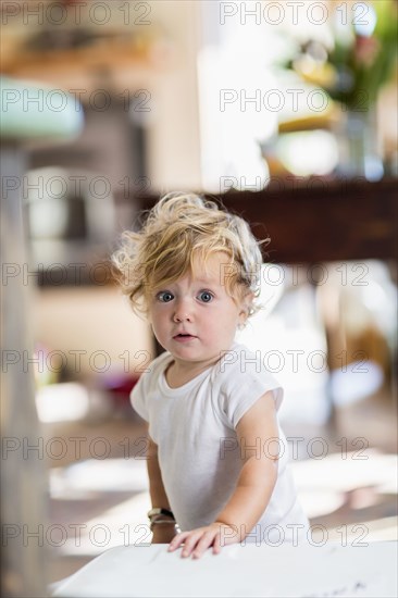 Surprised Caucasian baby boy standing indoors