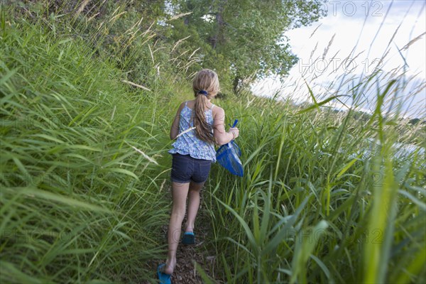 Caucasian girl walking in tall grass