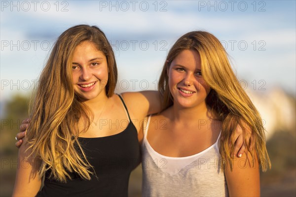 Teenage girls hugging outdoors