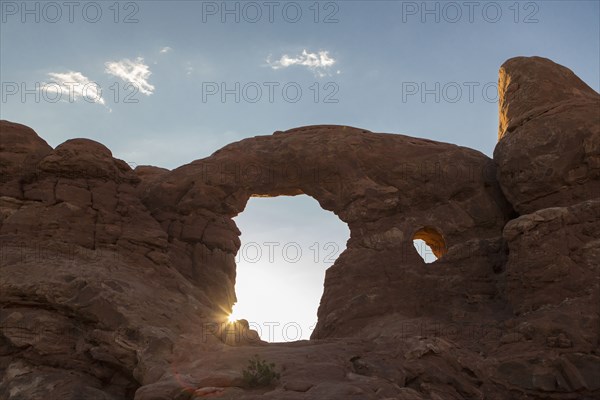 Low angle view of Turret Arch rock formation under blue sky