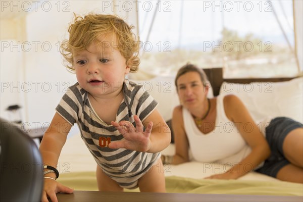 Caucasian mother watching baby son exploring