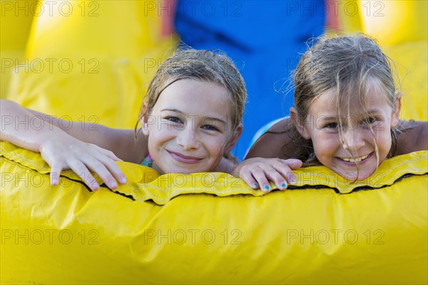 Caucasian girls playing together on inflatable castle
