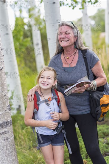 Caucasian grandmother and granddaughter hiking in forest