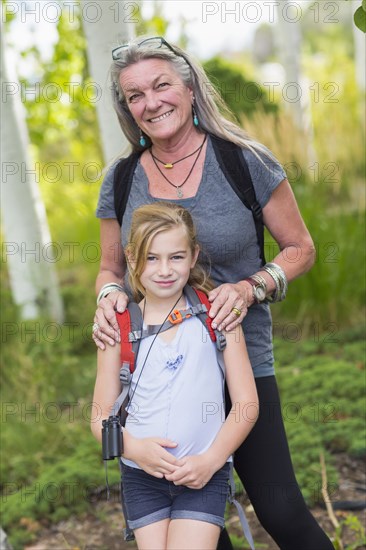 Caucasian grandmother and granddaughter smiling in forest