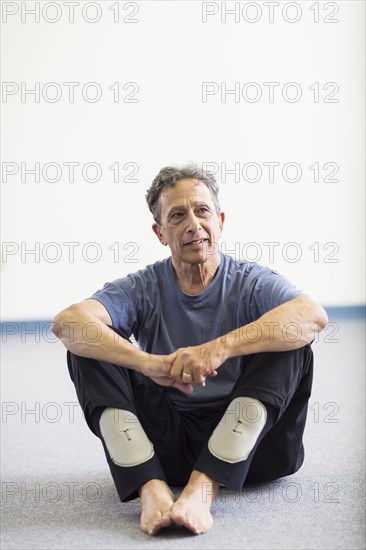 Senior Caucasian man sitting on floor