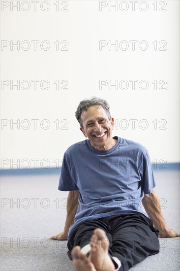 Senior Caucasian man smiling on floor