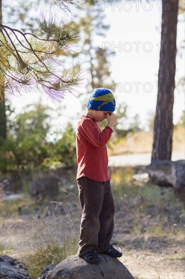 Caucasian boy standing on rock on hiking path