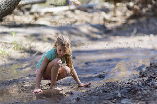 Caucasian girls exploring creek in forest