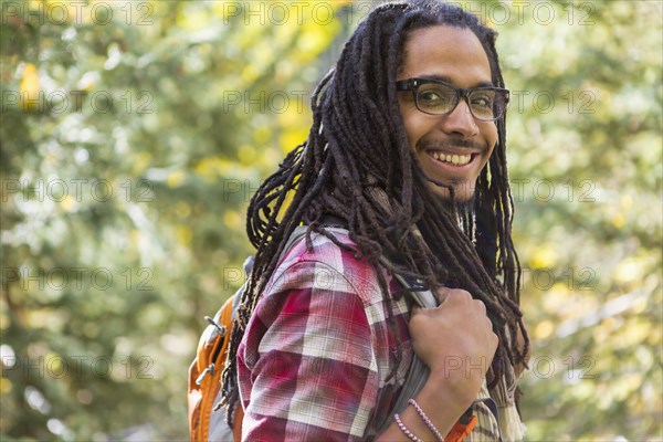 Mixed race man hiking in forest