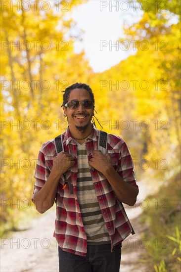 Mixed race man hiking in forest