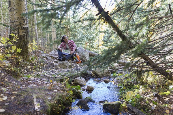 Mixed race hiker resting in forest