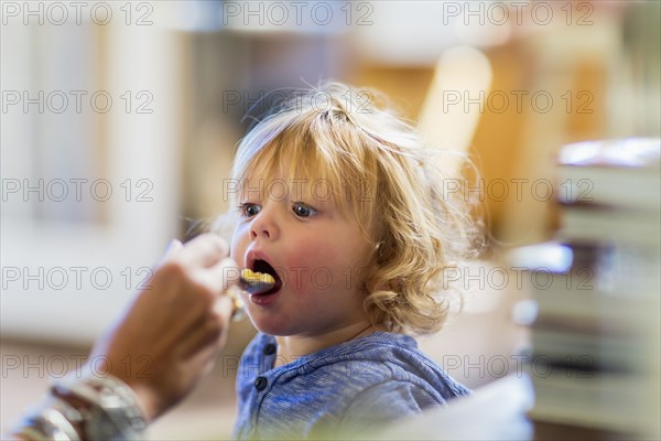 Mother feeding son at table