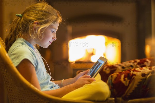 Caucasian girl using digital tablet in living room