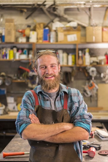 Caucasian craftsman smiling in workshop