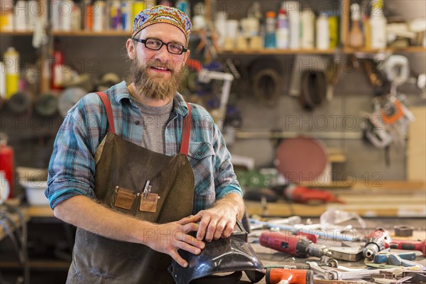 Caucasian craftsman smiling in workshop