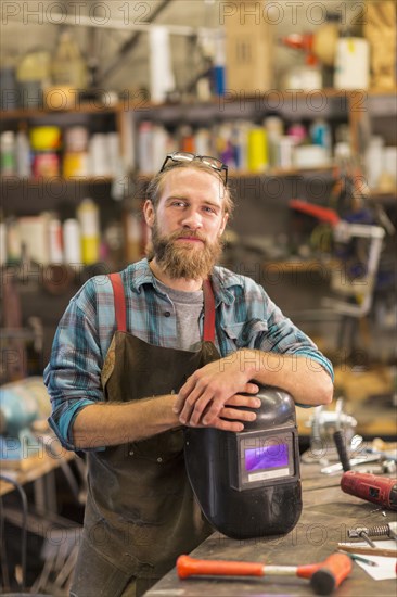 Caucasian craftsman smiling in workshop