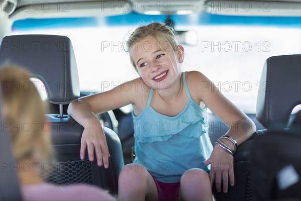 Caucasian girl sitting between seats in car