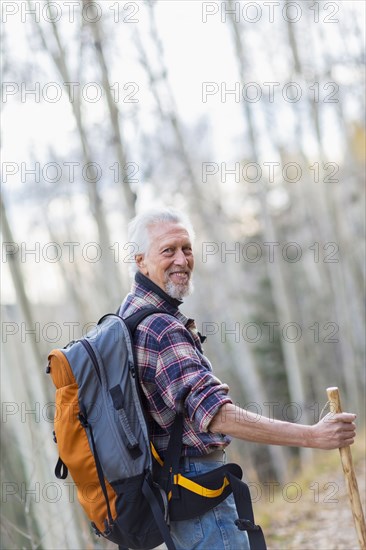 Caucasian hiker walking on dirt path in forest
