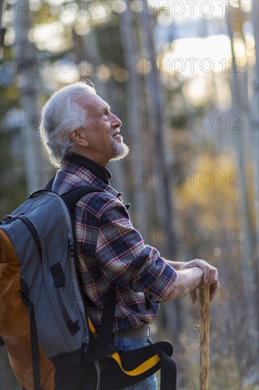 Caucasian hiker walking on dirt path in forest