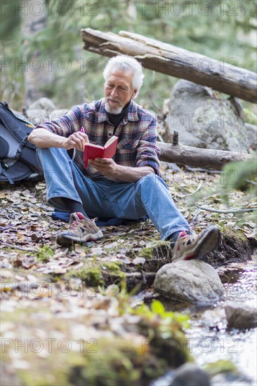 Caucasian hiker writing in forest