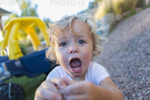 Caucasian boy shouting in backyard