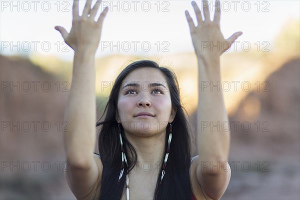 Mixed race woman meditating in desert