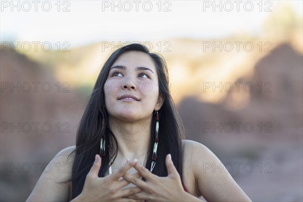 Mixed race woman meditating in desert