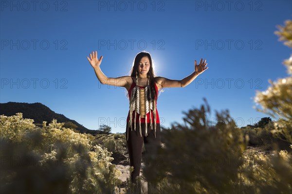 Mixed race woman meditating in remote desert landscape