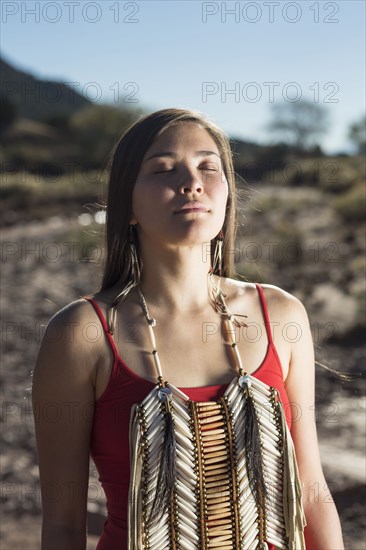 Mixed race woman meditating in remote desert landscape