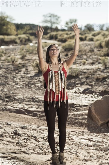 Mixed race woman meditating in remote desert landscape