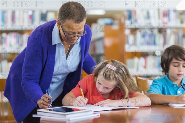 Teacher helping student in library
