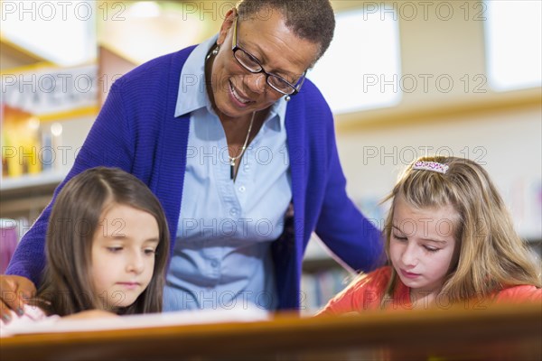 Teacher helping students in library