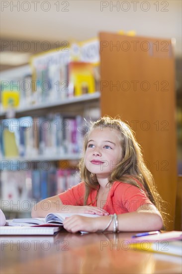 Caucasian student sitting at desk in library